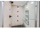 Modern tiled shower with glass door and a built-in niche, providing a luxurious showering experience at 6773 E Baker Pl, Denver, CO 80224