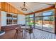 A sun room with hardwood floor, glass table set, large windows and sliding glass doors at 6773 E Baker Pl, Denver, CO 80224