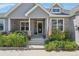 House entrance with a porch, American flag, and landscaping at 6847 S Windermere St, Littleton, CO 80120