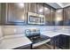 A kitchen featuring stainless steel appliances, including an oven and microwave, with dark cabinets at 899 Winding Brook Dr, Berthoud, CO 80513