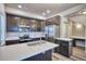 Modern kitchen with stainless steel appliances, dark cabinets, and a central island with a sink at 899 Winding Brook Dr, Berthoud, CO 80513