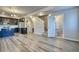 Open living space with modern flooring connecting the kitchen, stairs, and half bath at 899 Winding Brook Dr, Berthoud, CO 80513