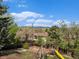 Picturesque backyard featuring a playground, fire pit, mature trees and mountain views at 7105 Dover Way, Arvada, CO 80004