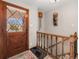 Front entryway featuring a decorative wooden front door, tiled floor, and staircase with wood and glass railings at 7105 Dover Way, Arvada, CO 80004