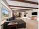 Large living room with a fireplace, wood beam ceilings, and big windows, plus piano and entertainment area at 7105 Dover Way, Arvada, CO 80004