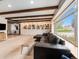 Bright living room featuring exposed wood beam ceilings, custom shelving, and a large picture window at 7105 Dover Way, Arvada, CO 80004