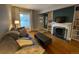 Inviting living room featuring hardwood floors, a cozy fireplace, and natural light from a large window at 422 E 6Th Ave, Denver, CO 80203