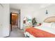 Bright bedroom featuring a rattan headboard, dresser with mirror, and view into the hallway at 3506 S Depew St # 3, Denver, CO 80235