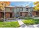 Inviting townhome with brick accents, lush lawn, and river rock landscaping at 3506 S Depew St # 3, Denver, CO 80235