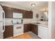 Efficient kitchen design with white appliances, wood cabinets, and practical layout for easy meal preparation at 3506 S Depew St # 3, Denver, CO 80235