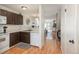 Functional kitchen with white appliances and dark cabinetry, leading to an open living space at 3506 S Depew St # 3, Denver, CO 80235
