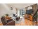 Bright living room features a stone fireplace, wood floors, and access to a private balcony at 3506 S Depew St # 3, Denver, CO 80235
