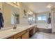 Spacious bathroom featuring double sinks, a large mirror, and a separate bathtub and shower at 10155 Silver Maple Cir, Highlands Ranch, CO 80129