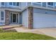 Home facade featuring brick accents, a two-car garage and an entrance framed by sidelights at 10155 Silver Maple Cir, Highlands Ranch, CO 80129