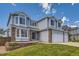 Charming two-story home with a three-car garage, manicured lawn, and brick accents at 10155 Silver Maple Cir, Highlands Ranch, CO 80129