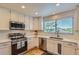 Bright kitchen with white cabinets, quartz countertops, subway tile backsplash, and stainless steel appliances at 10155 Silver Maple Cir, Highlands Ranch, CO 80129