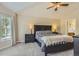 Comfortable main bedroom with a ceiling fan, large window, and an inviting bed with bedside tables and lamps at 10155 Silver Maple Cir, Highlands Ranch, CO 80129
