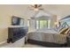 Inviting main bedroom featuring a ceiling fan, large window, and a bed with bedside tables and lamps at 10155 Silver Maple Cir, Highlands Ranch, CO 80129