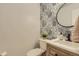 Stylish powder room featuring floral wallpaper, modern fixtures, and a decorative round mirror above a wooden vanity at 10155 Silver Maple Cir, Highlands Ranch, CO 80129