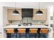Modern kitchen with large island, tan leather bar stools, stainless appliances and light wood cabinets at 732 S Gaylord St, Denver, CO 80209