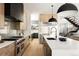 Spacious kitchen features stainless steel appliances, a large island, modern fixtures and natural wood finishes at 732 S Gaylord St, Denver, CO 80209