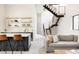 Open-concept living room with stylish bar seating, statement staircase, and comfortable seating for entertaining at 732 S Gaylord St, Denver, CO 80209