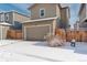 House exterior featuring a two-car garage and snowy yard at 6727 Canosa St, Denver, CO 80221