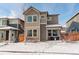 Two-story home with gray siding, snowy front yard, and small patio at 6727 Canosa St, Denver, CO 80221