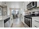 Modern kitchen with white cabinets, stainless steel appliances, and quartz countertops at 6727 Canosa St, Denver, CO 80221