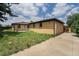 Exterior of the home with a spacious backyard, including a detached garage and lawn at 588 Empire St, Aurora, CO 80010