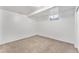 Clean basement featuring neutral carpet, white walls, and a small window for natural light at 588 Empire St, Aurora, CO 80010