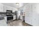 Modern kitchen featuring stainless steel appliances, white cabinets, and wood-look flooring at 588 Empire St, Aurora, CO 80010