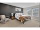 Inviting bedroom with a black accent wall, two windows for natural light, and comfortable chair and bedding at 221 Felicity Loop, Castle Rock, CO 80109