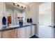 Dual sink bathroom with stylish vanity, granite countertop and access to an additional closet and bedroom at 5398 S Jay Dr, Littleton, CO 80123