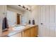 Bathroom with a double sink vanity, neutral tile countertops and floors, and two separate entrances at 5398 S Jay Dr, Littleton, CO 80123