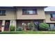 Charming townhome exterior with well-maintained lawn, colorful garden, and covered entryway at 442 S Carr St, Lakewood, CO 80226