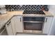 Modern kitchen featuring stainless steel oven, electric cooktop, and herringbone backsplash at 442 S Carr St, Lakewood, CO 80226