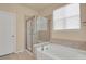 Bathroom featuring a glass-enclosed shower, soaking tub, and window at 1533 Bellflower Dr, Brighton, CO 80601