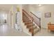 Inviting foyer featuring tiled flooring, a staircase with wood railing, and ample natural light from nearby windows at 1533 Bellflower Dr, Brighton, CO 80601