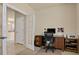Cozy home office space with neutral tones and ample storage and an open door into another room at 1533 Bellflower Dr, Brighton, CO 80601