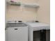 Functional laundry room with washer, dryer and storage shelves at 1533 Bellflower Dr, Brighton, CO 80601