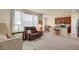 Inviting living room showcasing plush seating, neutral carpet, and an open layout leading to the kitchen at 1533 Bellflower Dr, Brighton, CO 80601