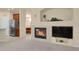Open-concept view from a living room to the kitchen featuring a fireplace and neutral carpet at 1533 Bellflower Dr, Brighton, CO 80601