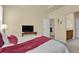 Relaxing main bedroom featuring plush bedding and a view into the bathroom at 1533 Bellflower Dr, Brighton, CO 80601