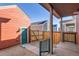 A fenced backyard with a coral colored garage and a small patio area at 10331 E 62Nd Pl, Denver, CO 80238