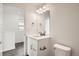 This well-lit bathroom has a white vanity, granite countertop, and dark wood-look flooring at 10331 E 62Nd Pl, Denver, CO 80238