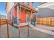 Charming orange home featuring a quaint front porch, teal door, and minimalistic xeriscaped yard at 10331 E 62Nd Pl, Denver, CO 80238