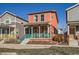 Charming two-story home features a welcoming front porch with teal railing and a vibrant coral exterior at 10331 E 62Nd Pl, Denver, CO 80238