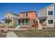 Charming two-story home features a welcoming front porch with teal railing and a vibrant coral exterior at 10331 E 62Nd Pl, Denver, CO 80238