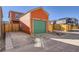 Garage with green doors and orange exterior and driveway at 10331 E 62Nd Pl, Denver, CO 80238